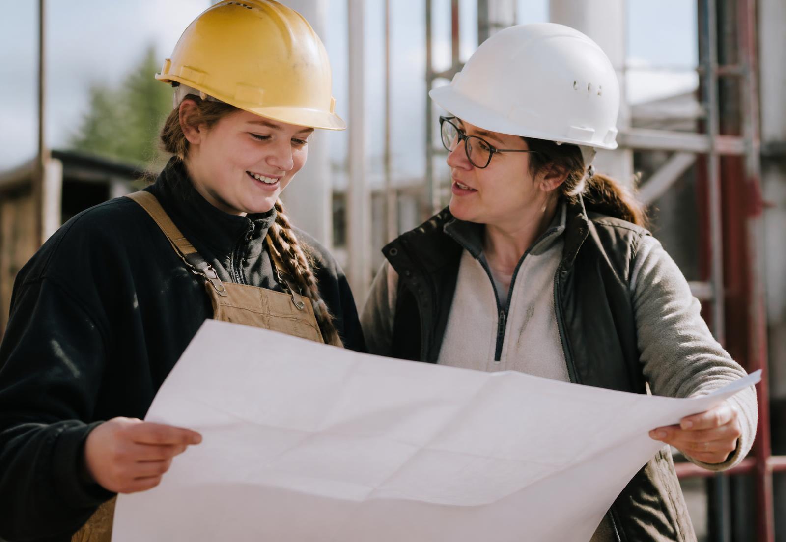 An apprentice and an experienced construction professional reviewing plans together