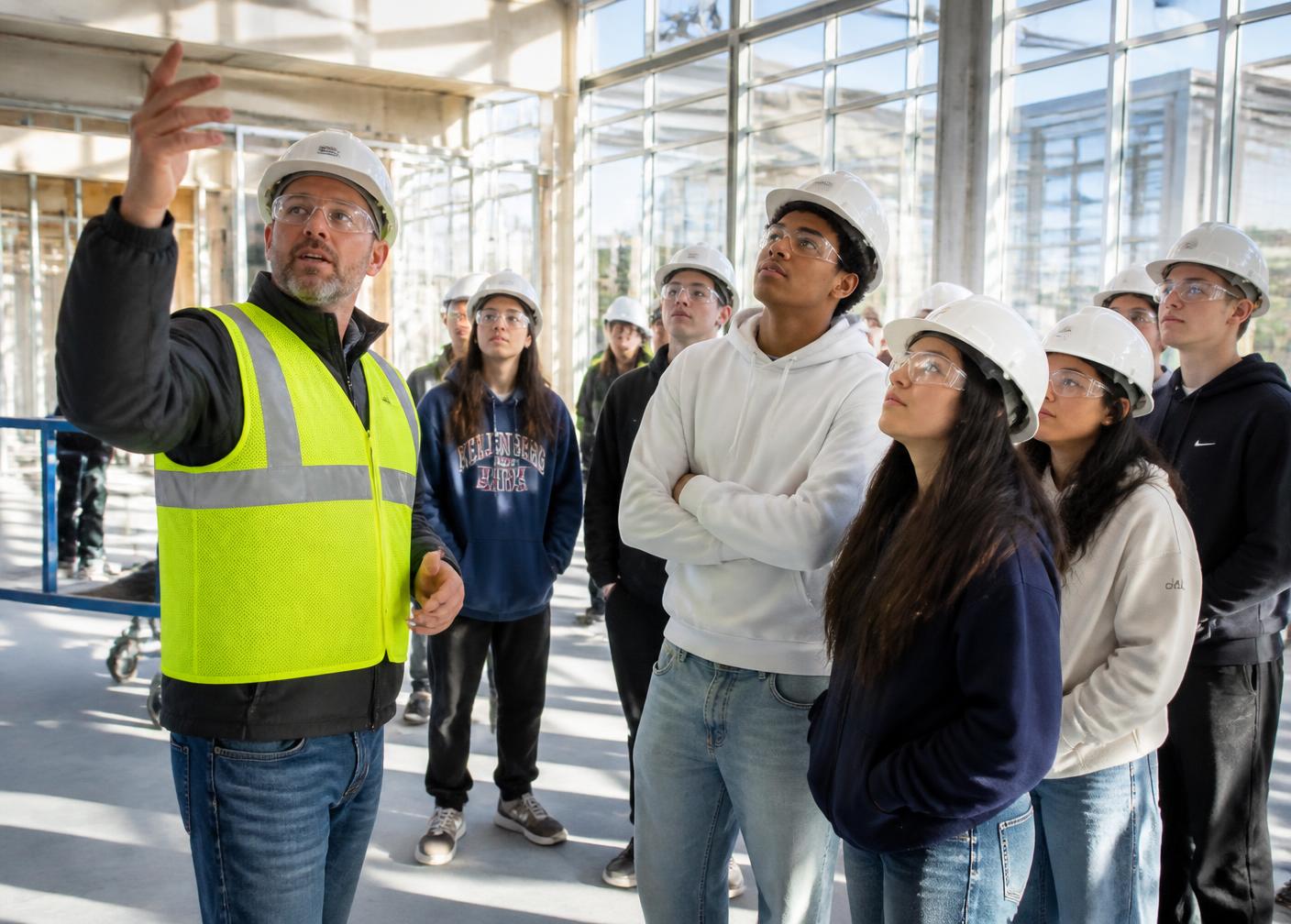 Students touring a building under construction with a mentor