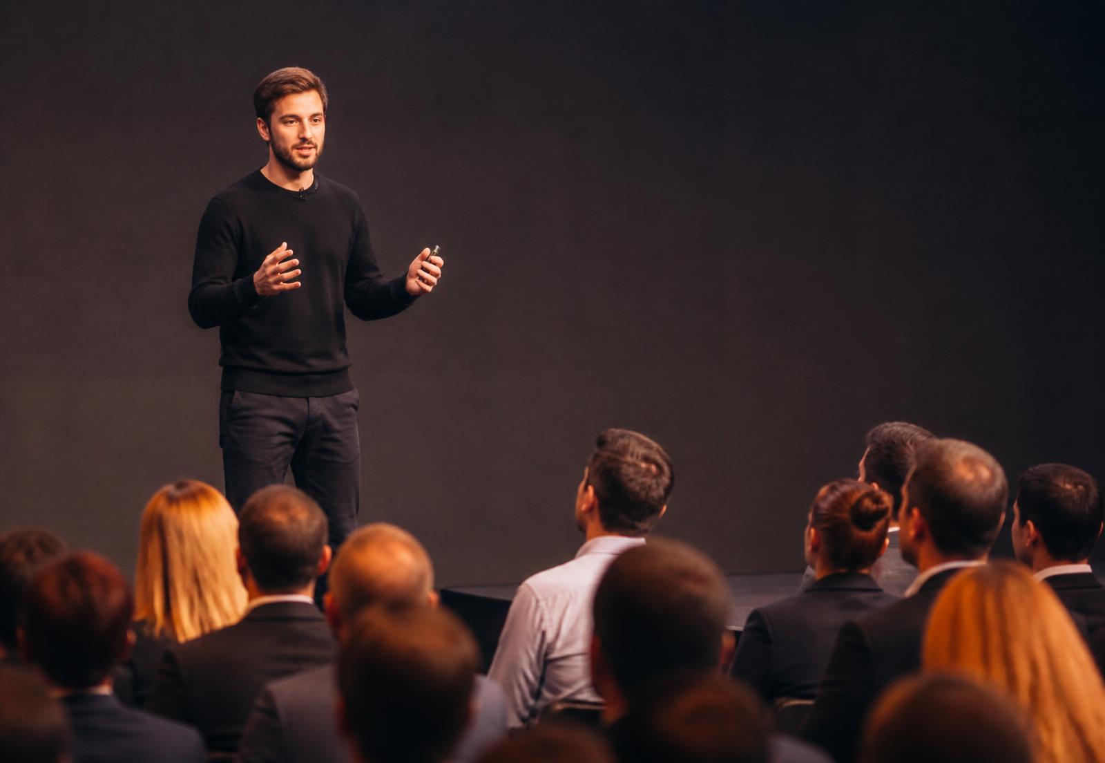 A young entrepreneur presenting to an audience of industry professionals