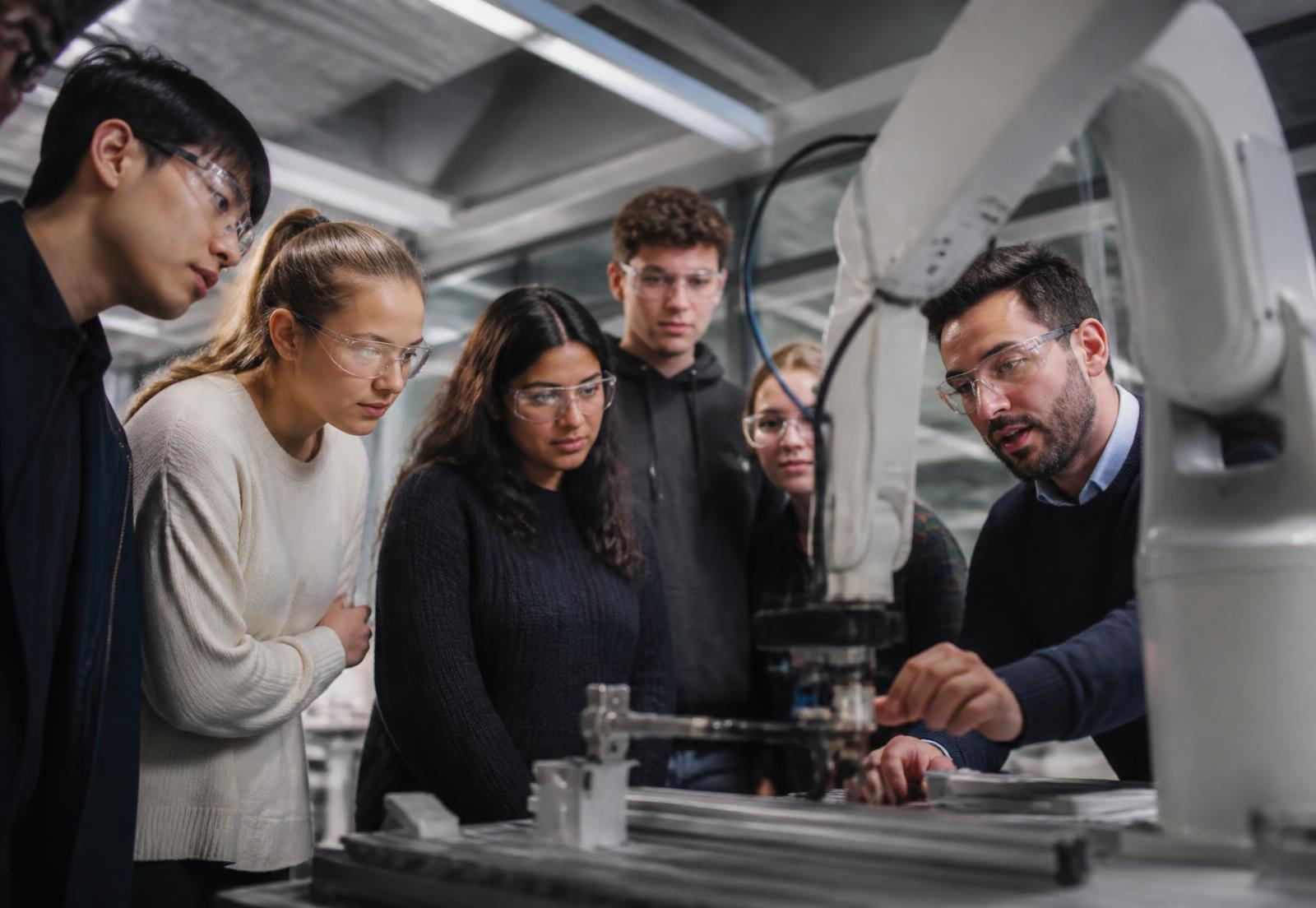 Students watching a robotics demonstration in an advanced manufacturing lab